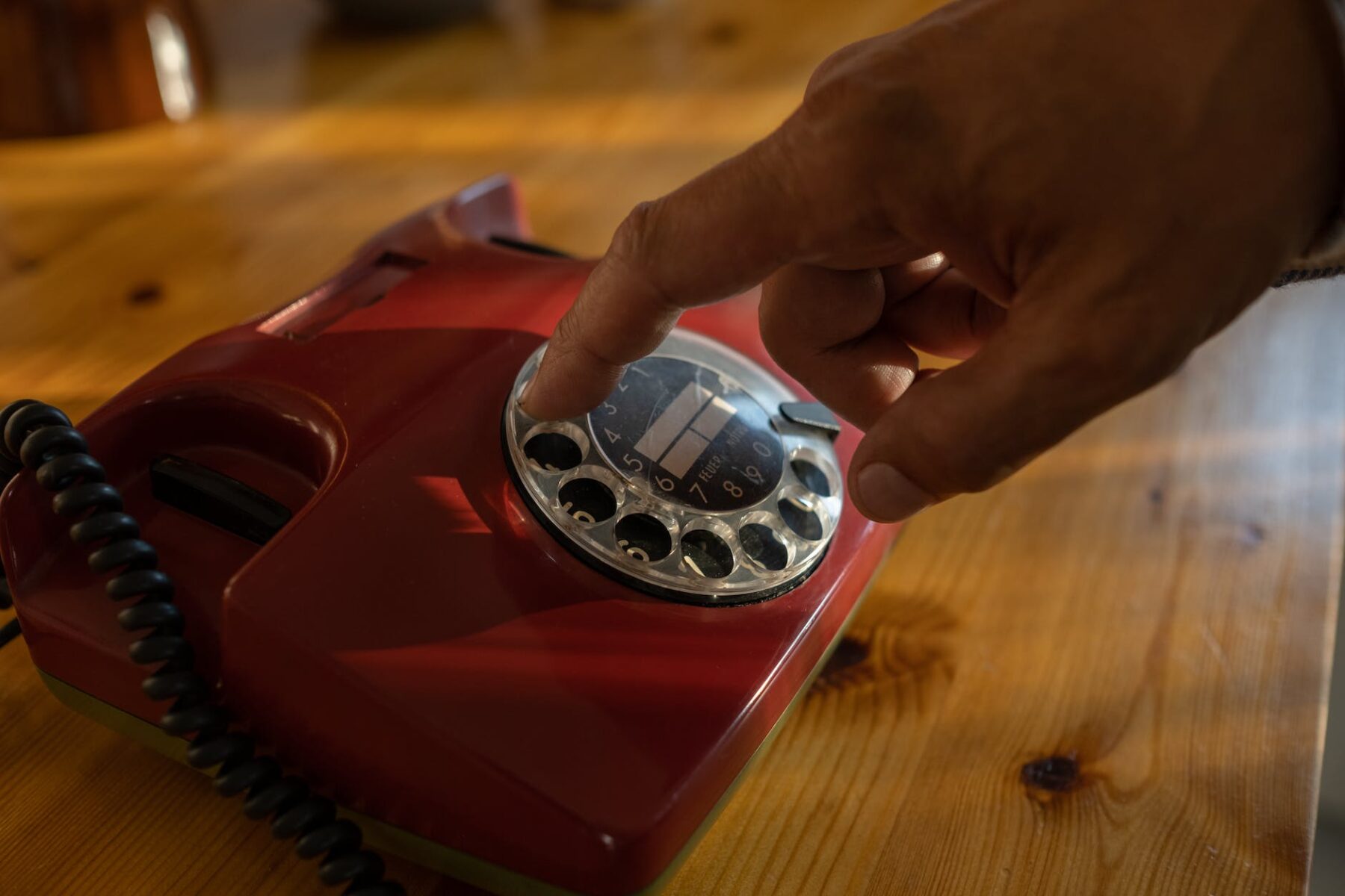 close up of mans hand dialing on rotary phone
